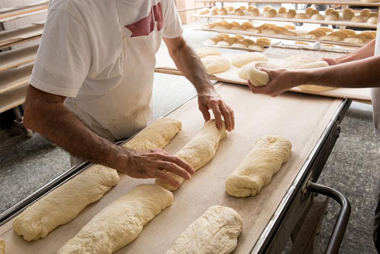 Piekarz przygotowuje ciasto na pieczywo